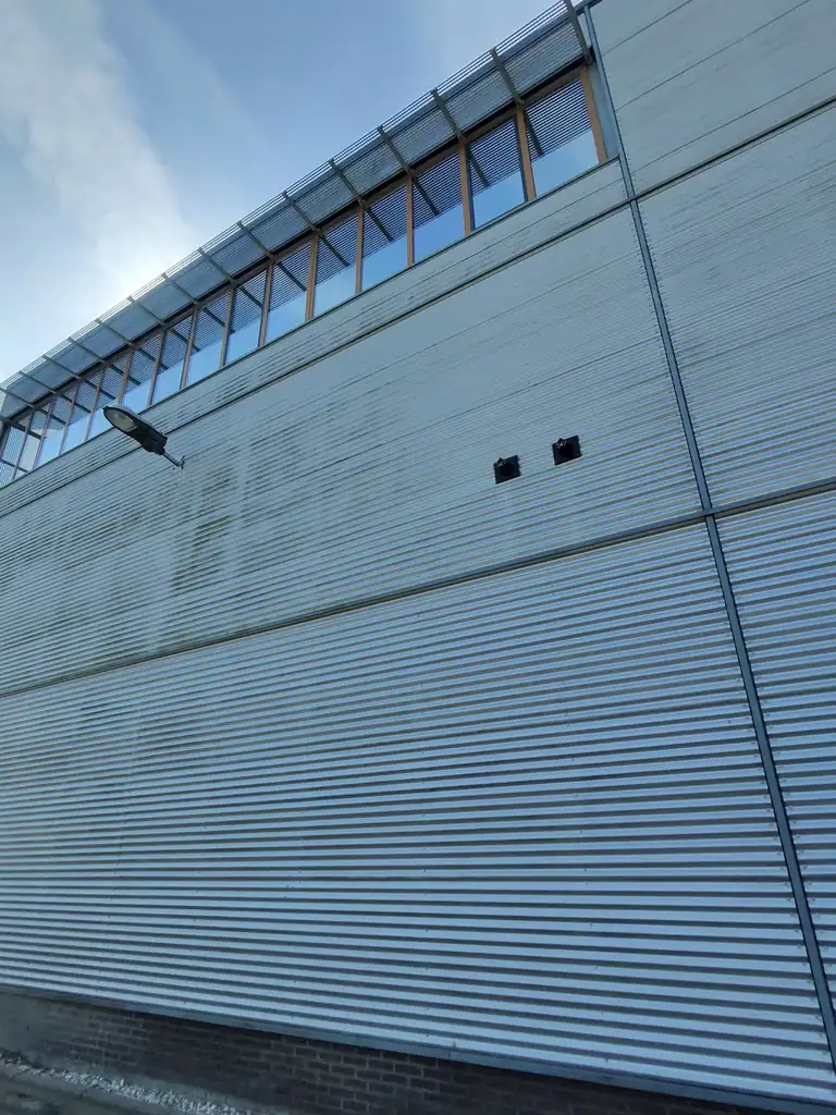 Gevelbeplating met regenwaterstrepen bij Handycare in Heerhugowaard — voor de reiniging