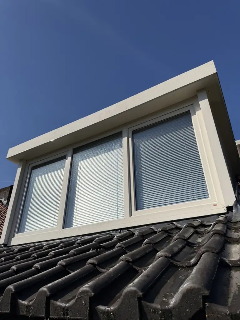 Dezelfde dakkapel met schoon wit kozijn — na de reiniging
