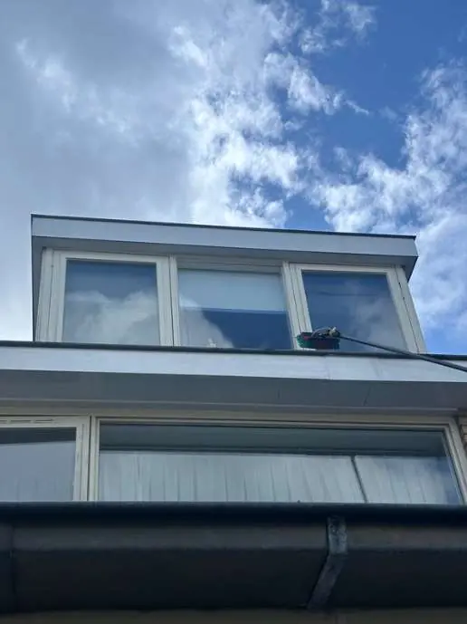 Schone dakkapel met ramen tegen een blauwe lucht