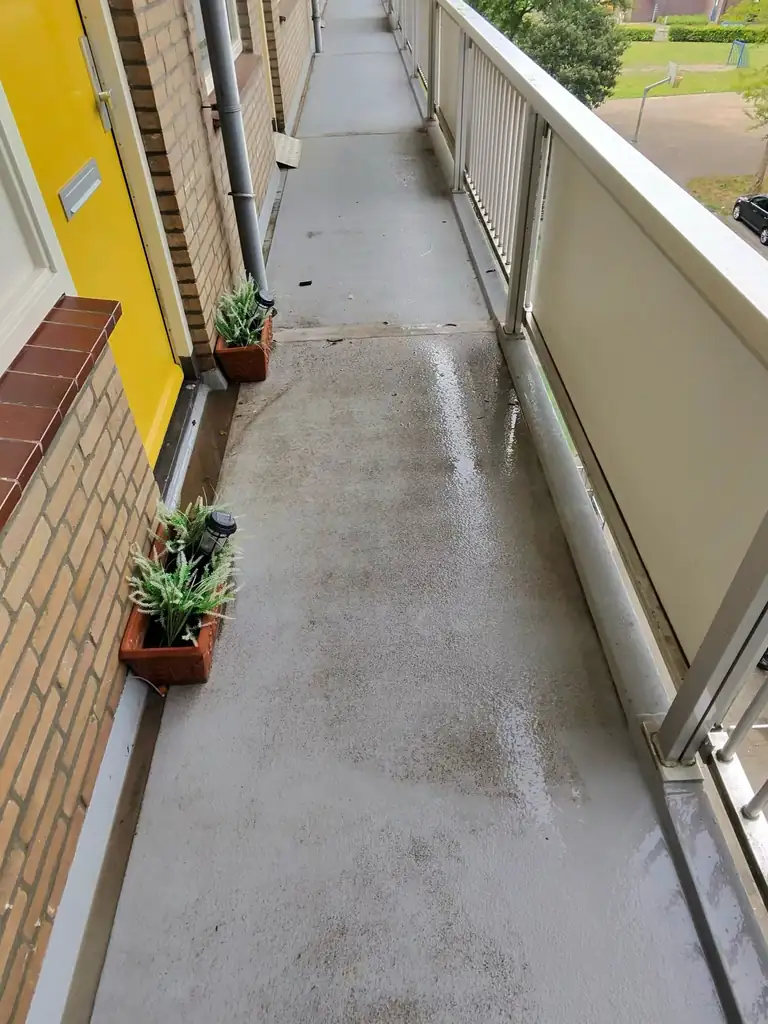 Galerijvloer van een flat in Oudorp, Alkmaar, met ingelopen vuil — voor de reiniging